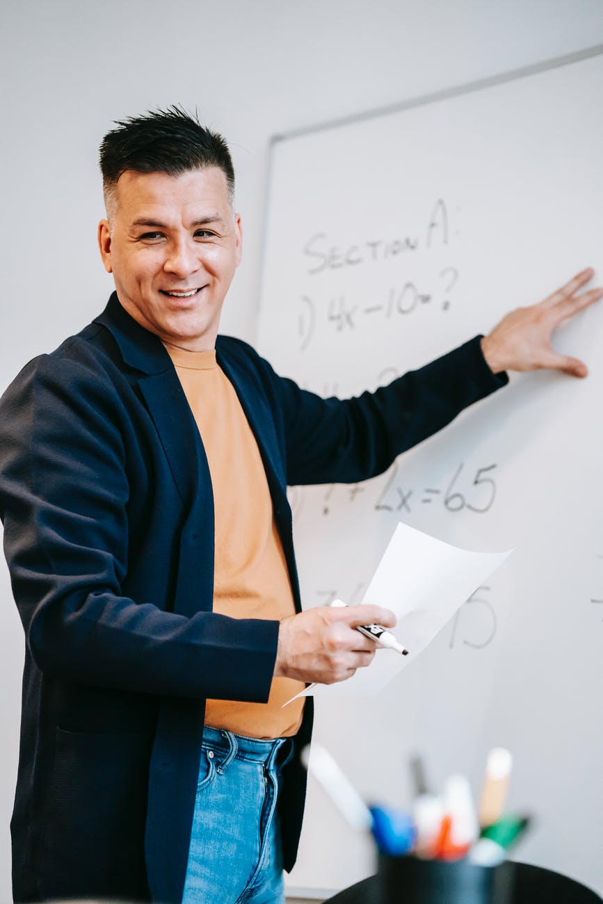 photo of man discussing on white board